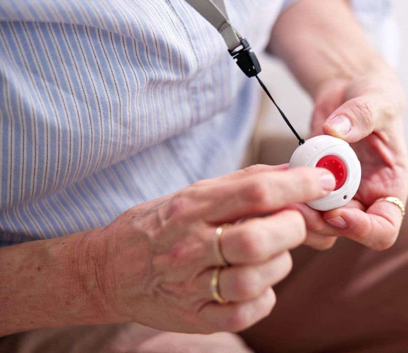 Elderly woman holding wearable alarm
